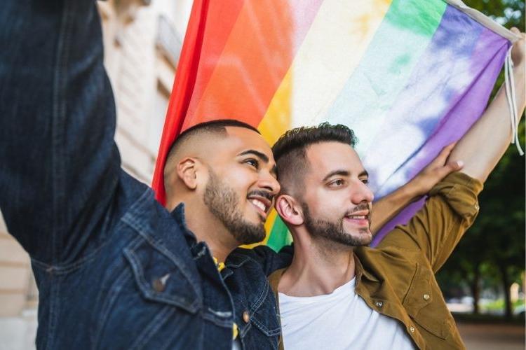 gay couple celebrating pride with pride flag